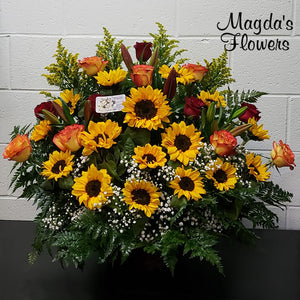 Beautiful sunflowers, roses and burgundy lilies in a large basket. 