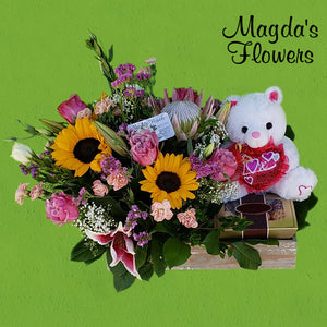 Sunflowers, King Protea, Lilies, Roses, a teddy and more in this beautiful floral arrangement.